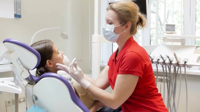 4k video of dentist inspecting tenager girls teeth in dental clinic