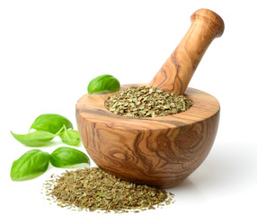 dried herb, basil leaves in the wooden mortar, isolated on white
