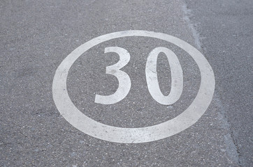 30 speed limit sign painted on a street