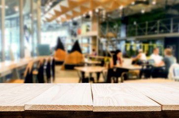 Selected focus empty brown wooden table and Coffee shop or restaurant blur background with bokeh image. for your photomontage or product display.