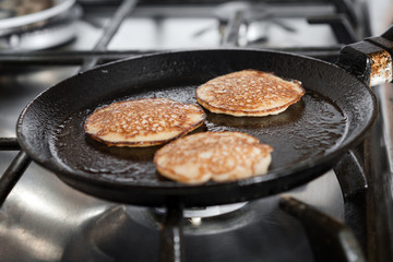 The process of cooking pancakes on a hot skillet