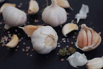 Food Photography. Food Preparing. Garlic with Spices on Black Background. Salt and Pepper.