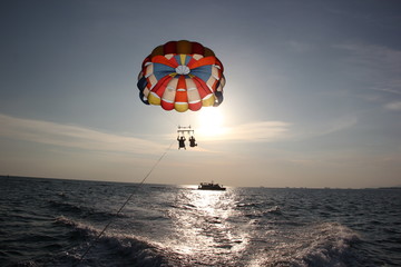 A man and a girl are flying on a parachute.