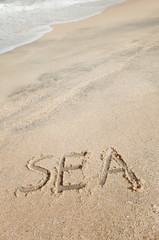 Handwriting text 'SEA' on sand beach with foam wave 2