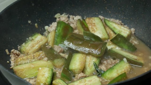 put herbal green sweet basil leaves into the black teflon pan  for  stir fried  green sliced piece eggplants , minced pork , sliced garlic, chili shrimp paste and food palm oil  together