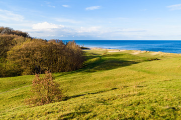Fototapeta na wymiar Havang, Sweden. Landscape view over grass covered sand dunes with the Baltic sea in the background on a sunny spring evening.