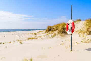 Malarhusen, Sweden - Lifebuoy on an empty sandy beach on a sunny day. - 203872858
