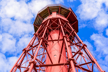 Sandhammaren, Sweden - Close up of the lighthouse and its framework. Blue sky with white clouds in the background.