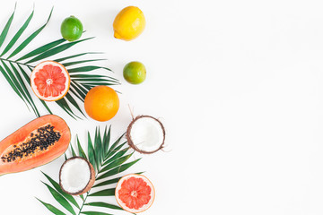 Summer tropical composition. Green palm leaves and tropical fruits on white background. Summer concept. Flat lay, top view, copy space