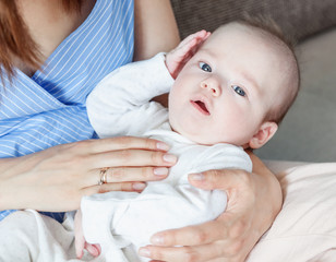 Beautiful happy young brunette woman with newborn baby on her hands, family happiness, love and care concept