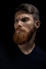 Portrait of stylish handsome adult man with beard. Man looking aside