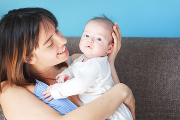 Beautiful happy young brunette woman with newborn baby on her hands, family happiness, love and care concept