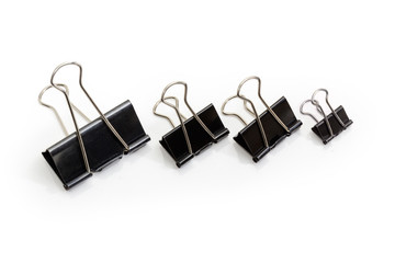 Several binder clips different sizes on a white background