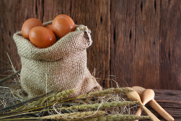 fresh egg in sack with grass on wood background