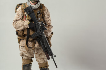 Soldier in camouflage holding rifle