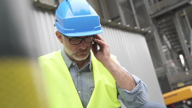 Industrial engineer in recycling plant using phone