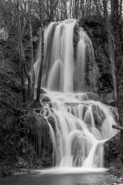 Beautiful Serbian waterfall long time exposure photography, water motion in black and white. Winter close-up image