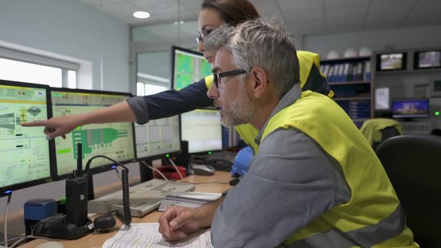 Technicians working in industrial plant control room