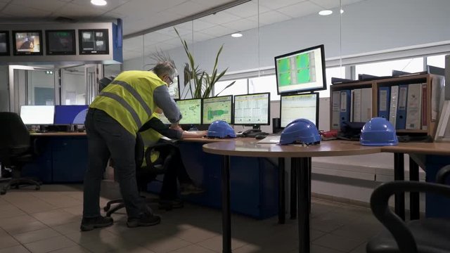 Technicians working in industrial plant control room