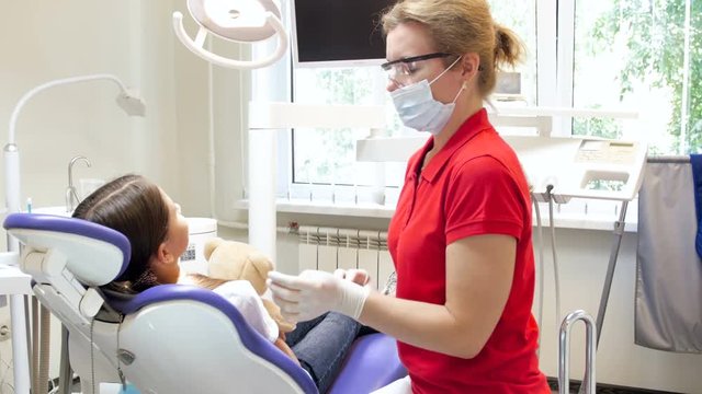 4k footage of dentist shaking girl's hand after teeth treatment