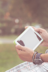 Detail of a man using tablet in the park.