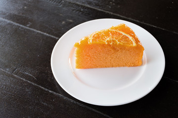 Orange cake on white plate wood table