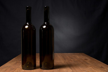 Wine bottles on the table against wooden background