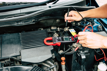 Fototapeta premium Checking power of battery by clamp meter, maintenance car by yoursalf, Monthly check.