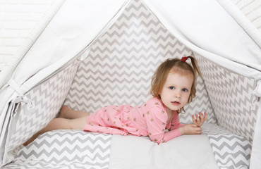 Lovely 2 years little girl lying in wigwam tent at home © ivolodina