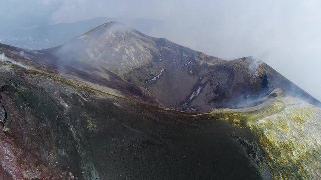 Aerial moving backwards away from Mount Etna peak an active volcano on east coast Sicily is highest active volcano in Europe and one of most active volcanoes in world in constant state of activity 4k