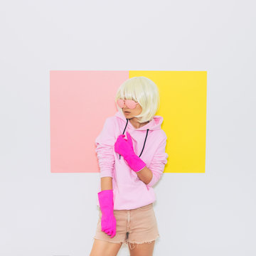Doll Blonde Girl Model in Fashion accessory sunglasses, gloves,  hoodie and shorts. Club Party Fun. Minimal unicorn style. Pink and yellow neon colors