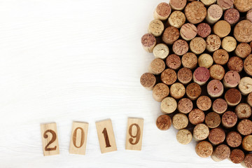 gourmet collection 2019/ wooden figures next to a set of previously open wine corks lying on the table top view