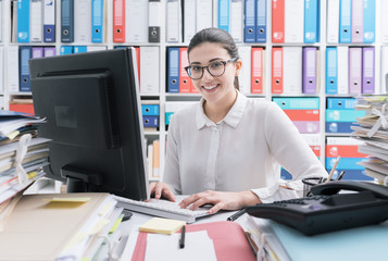 Young secretary working and smiling - obrazy, fototapety, plakaty