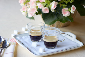 two coffee cups of espresso coffee on the table on a  porcelain tray