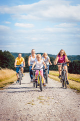 Family riding their bicycles on afternoon in the summer countryside
