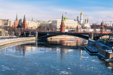 Obraz premium The most recognizable Moscow panoramic view. Bolshoy Kamenny Bridge over the Moscow river. Ancient Kremlin fortress and white stone cathedrals, crowned with golden domes.