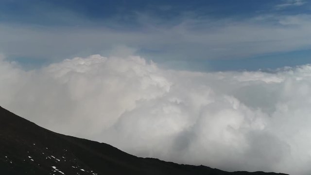 Aerial panning left towards Mount Etna peak an active volcano on east coast Sicily is highest active volcano in Europe and one of most active volcanoes in world in almost constant state of activity 4k