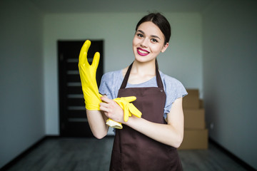 People, housework, safety and housekeeping concept. Young woman hands wearing protective rubber gloves at home