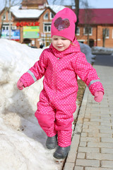 Little lovely 2 years girl walks in warm clothes in wintertime