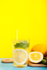 Tasty and organic detox water with lemons over yellow background in studio photo