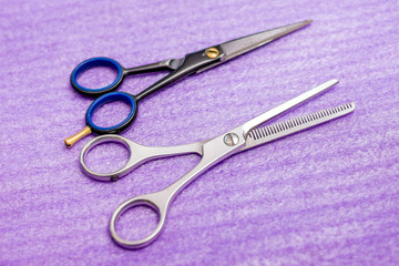 Professional hairdressing scissors on  purple napkin. Equipment for modern hairdressing salons_