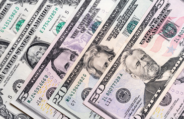 US dollar bills placed evenly on plain surface 