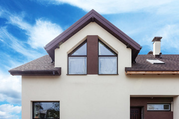 Fototapeta na wymiar Facade of modern house with metal tile, skylights and plastic or pvc windows
