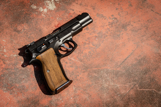 Black 9mm Auto Pistol on the concrete red backgroound