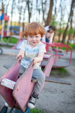 The boy plays in the playground.