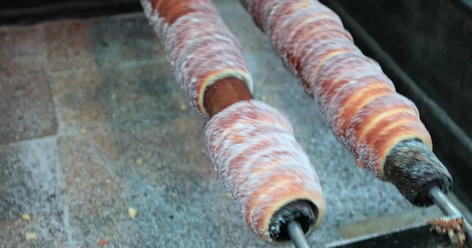 Hungarian cinnamon chimney cake sweet dessert being cooked grilled prepared on the street5