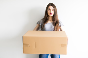 Young woman holding cardboard box moving into new home.