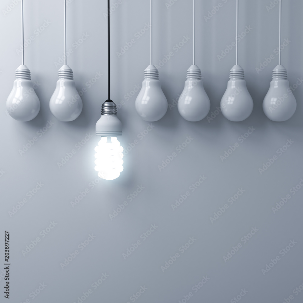 Fototapete one hanging eco energy saving light bulb glowing and standing out from unlit incandescent bulbs on w
