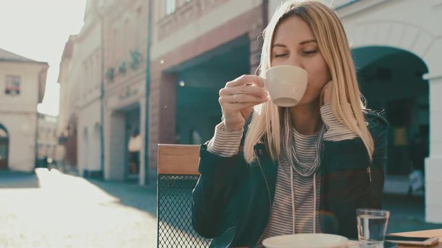 Woman drink coffee outdoor at sun day.