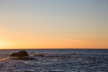 View of orange sunset with rocks in water